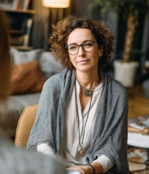 A female therapist listens attentively during a counseling session, representing individual therapy support.