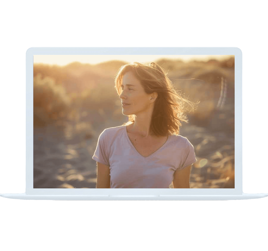 A woman looking thoughtful in golden evening light, displayed on a laptop screen — online depression counseling.