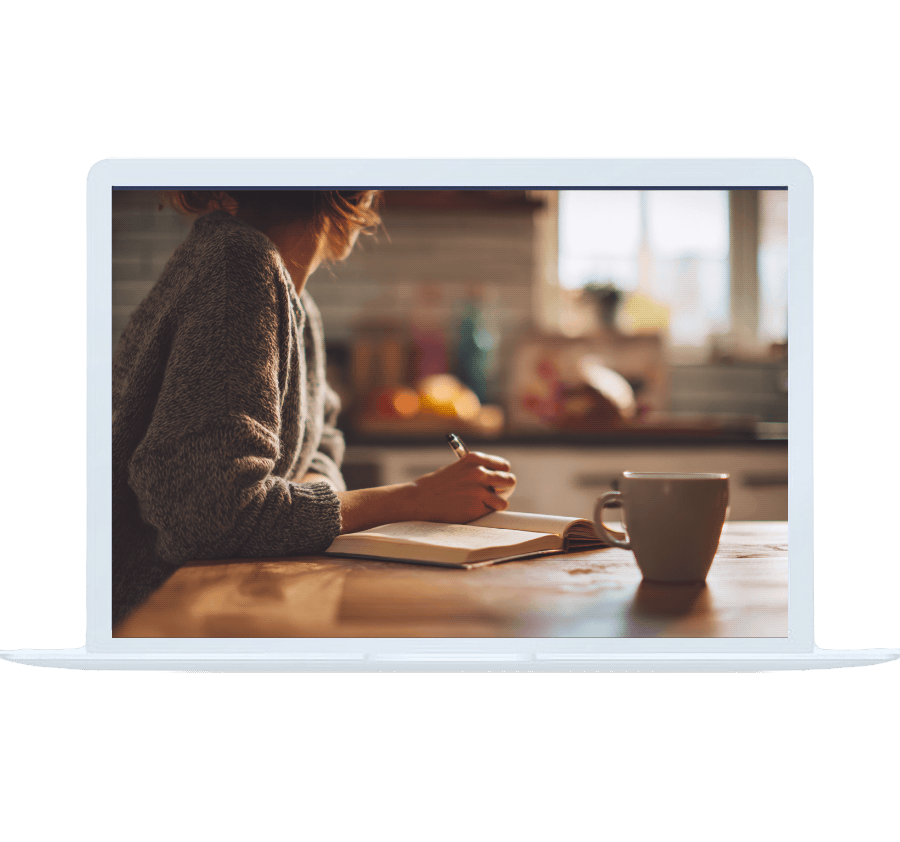 A person writes in a notebook with coffee nearby, capturing moments of clarity during online OCD counseling.